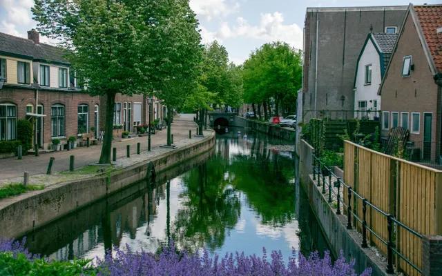 Straatbeeld met een gracht en woonhuizen in een Nederlandse plaats